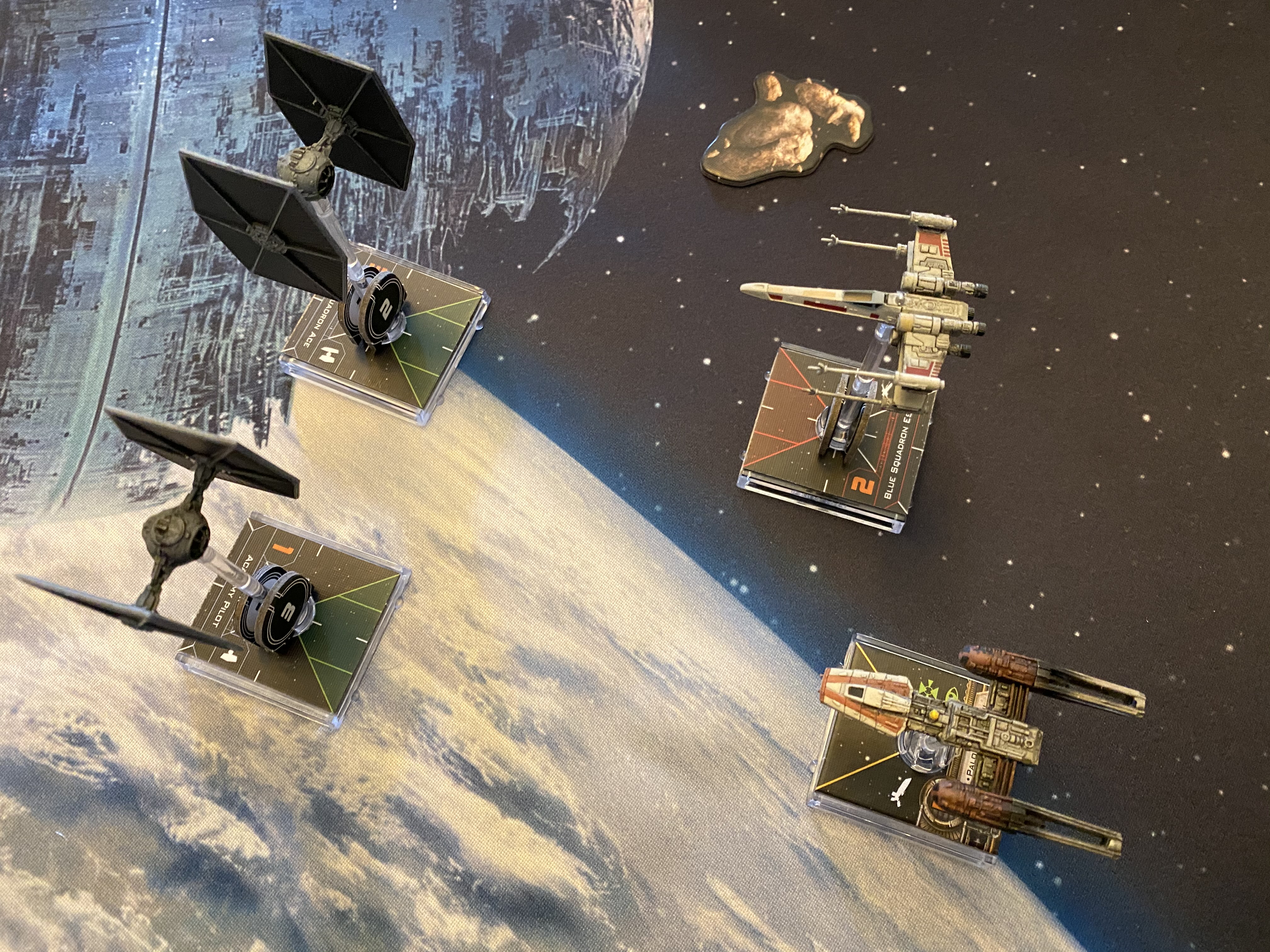 Four small ships (2 TIE fights, an X-wing, and a Y-wing) prepare to engage in battle over the Death Star.